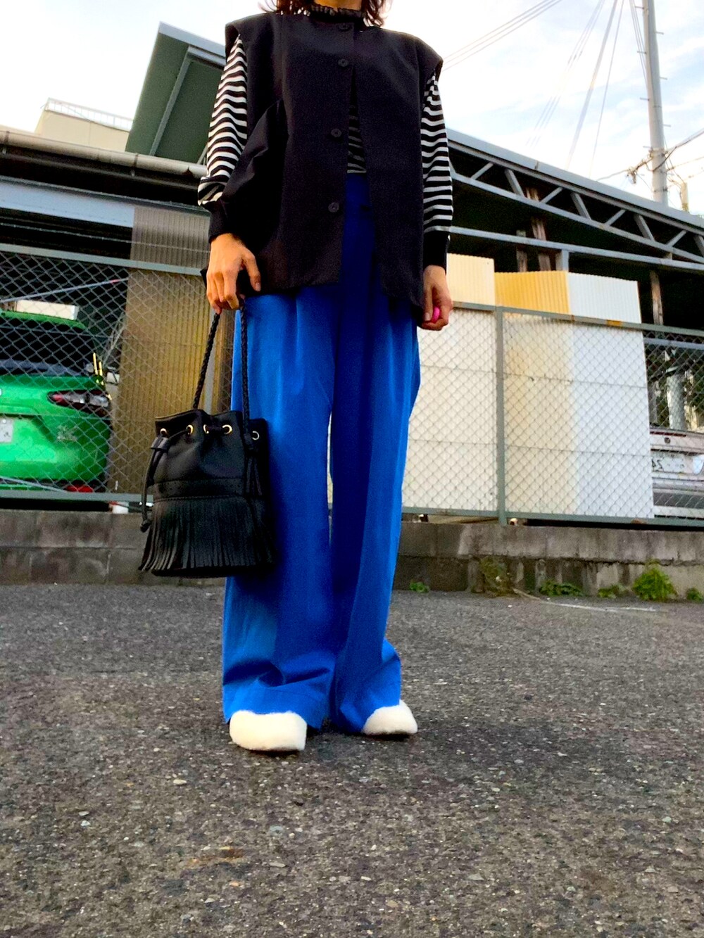 ブラック系のニット/セーター、ブルー系のパンツ、ホワイト系のシューズを着用したレディースの秋コーディネートの3枚目の写真