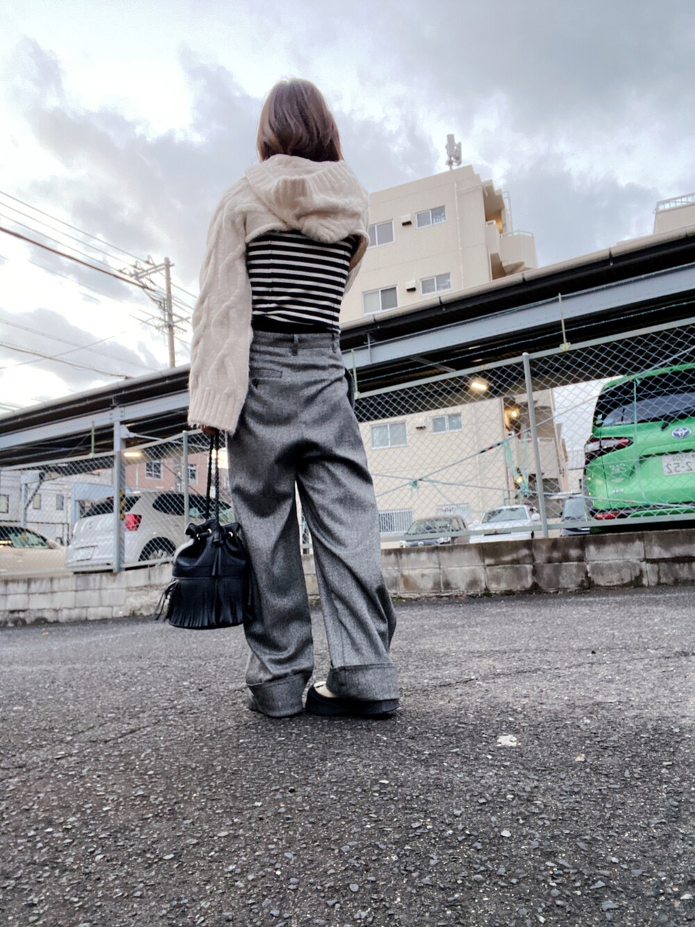 ホワイト系のニット/セーター、ブラック系のニット/セーター、グレー系のパンツを着用したレディースの冬コーディネートの2枚目の写真