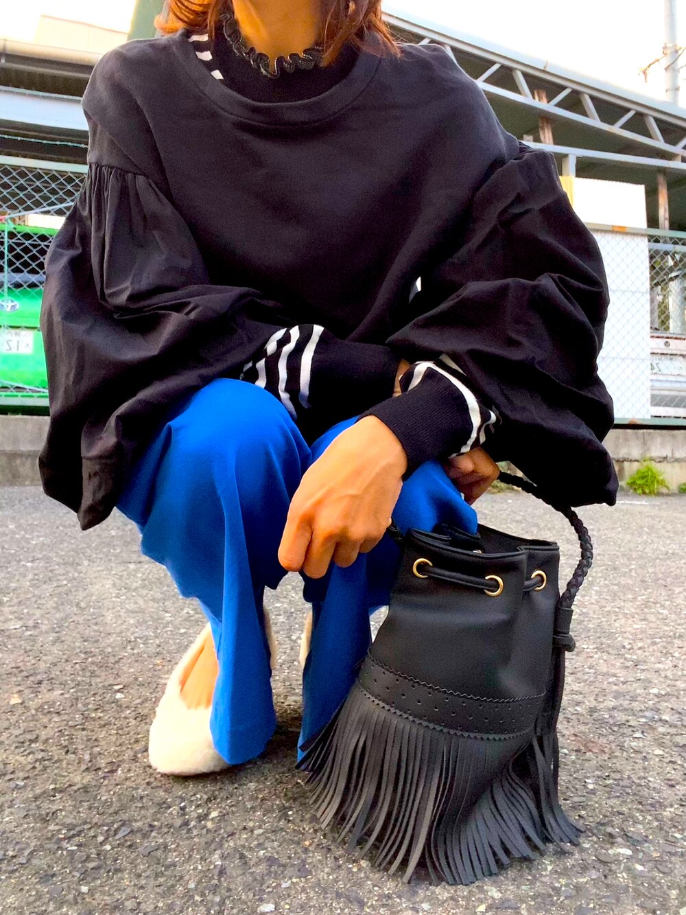 ブラック系のニット/セーター、ブルー系のパンツ、ホワイト系のシューズを着用したレディースの秋コーディネートの4枚目の写真