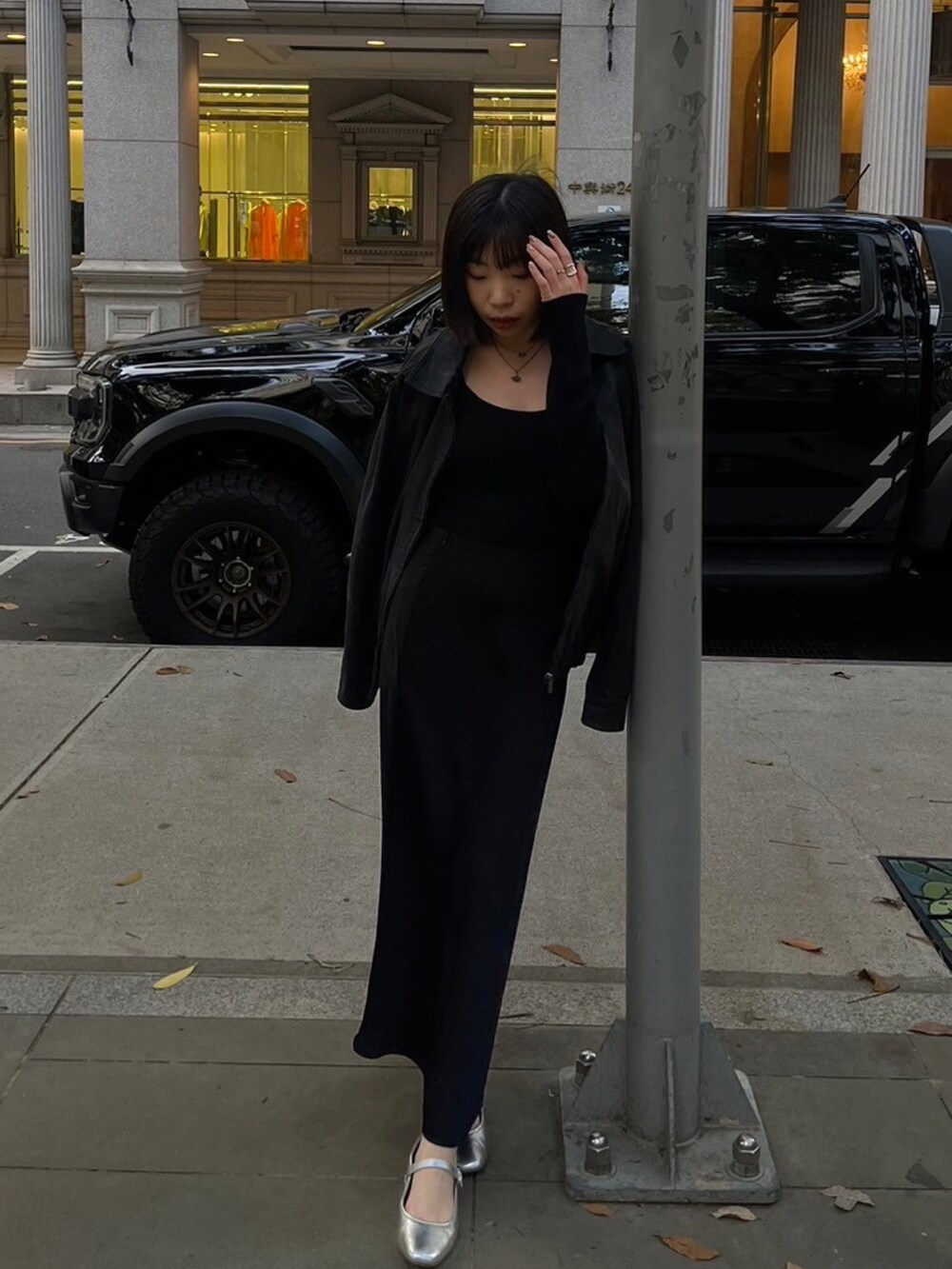 シルバー系のバレエシューズ、ブラック系のカーディガン/ボレロ、グレー系のネックレスを着用したレディースの冬コーディネートの2枚目の写真