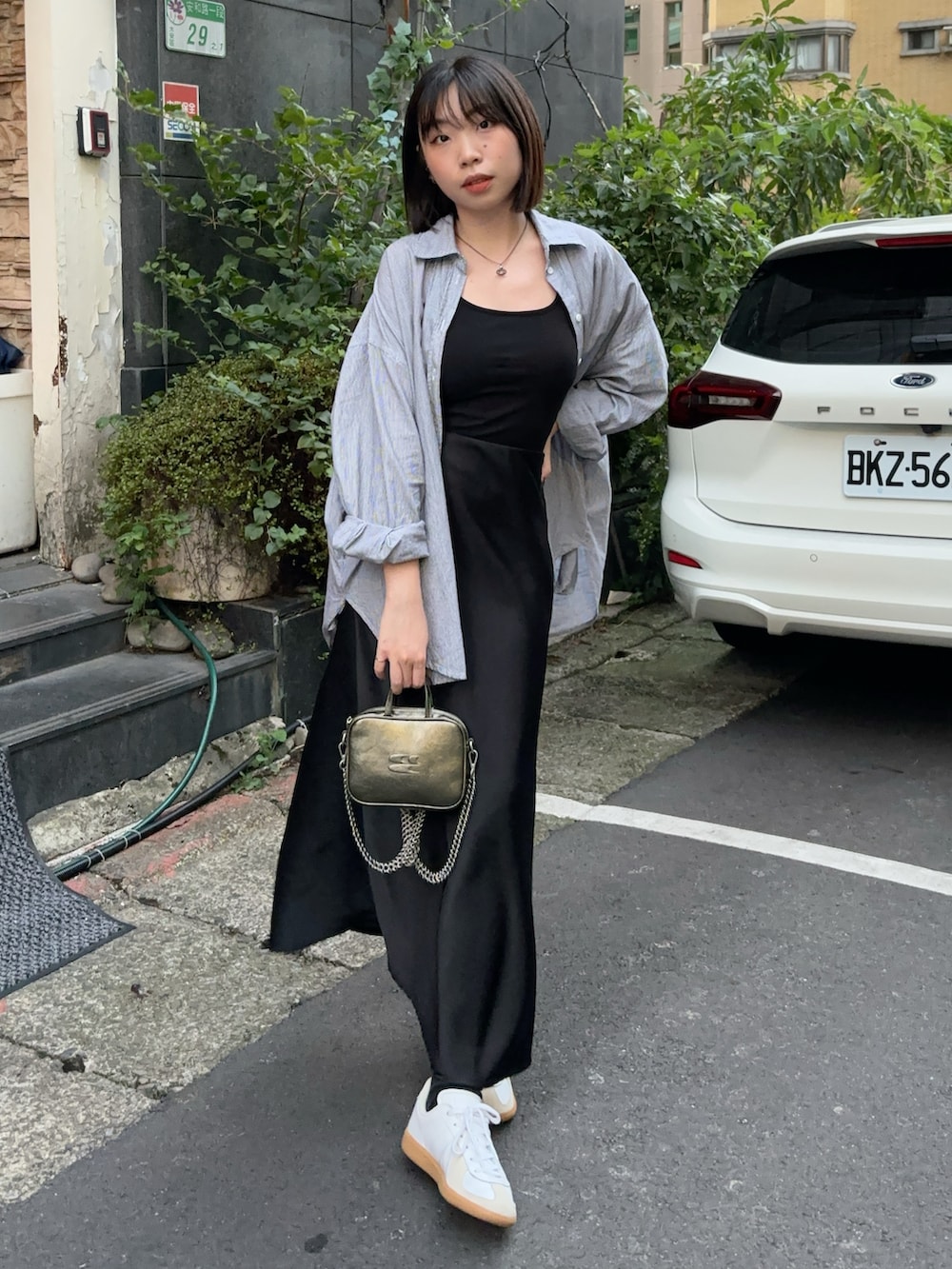 ブルー系のシャツ/ブラウス、グリーン系のトートバッグ、ホワイト系のスニーカーを着用したレディースの冬コーディネートの2枚目の写真