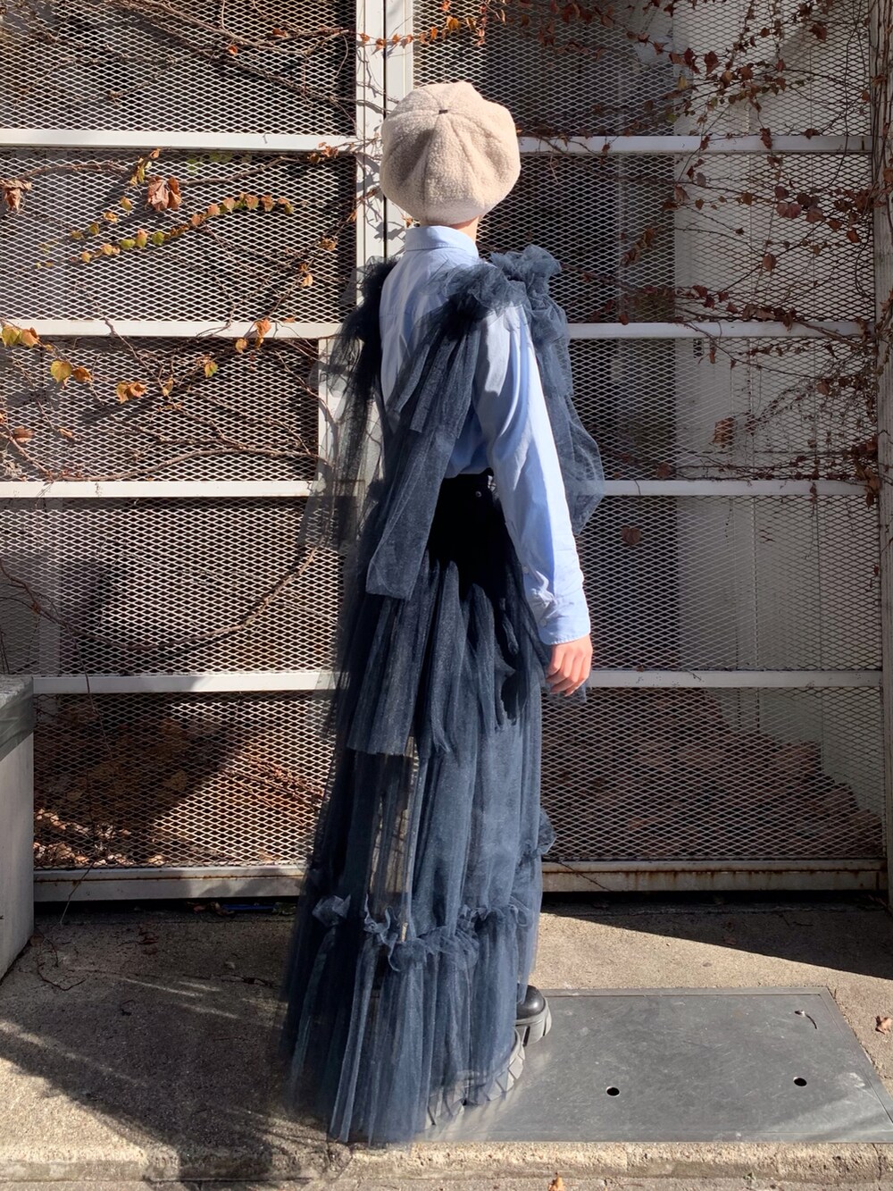 ブルー系のワンピース、ホワイト系のハンチング/ベレー帽を着用したレディースの冬コーディネートの2枚目の写真