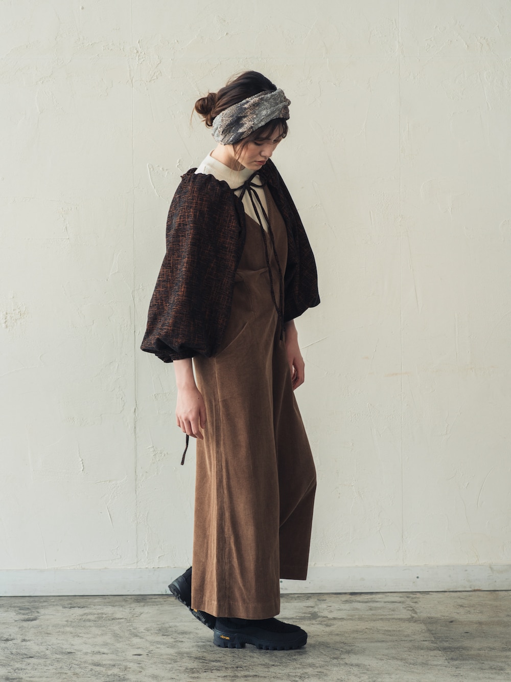 オレンジ系のカーディガン/ボレロ、グレー系のヘアバンドを着用したレディースの冬コーディネートの2枚目の写真