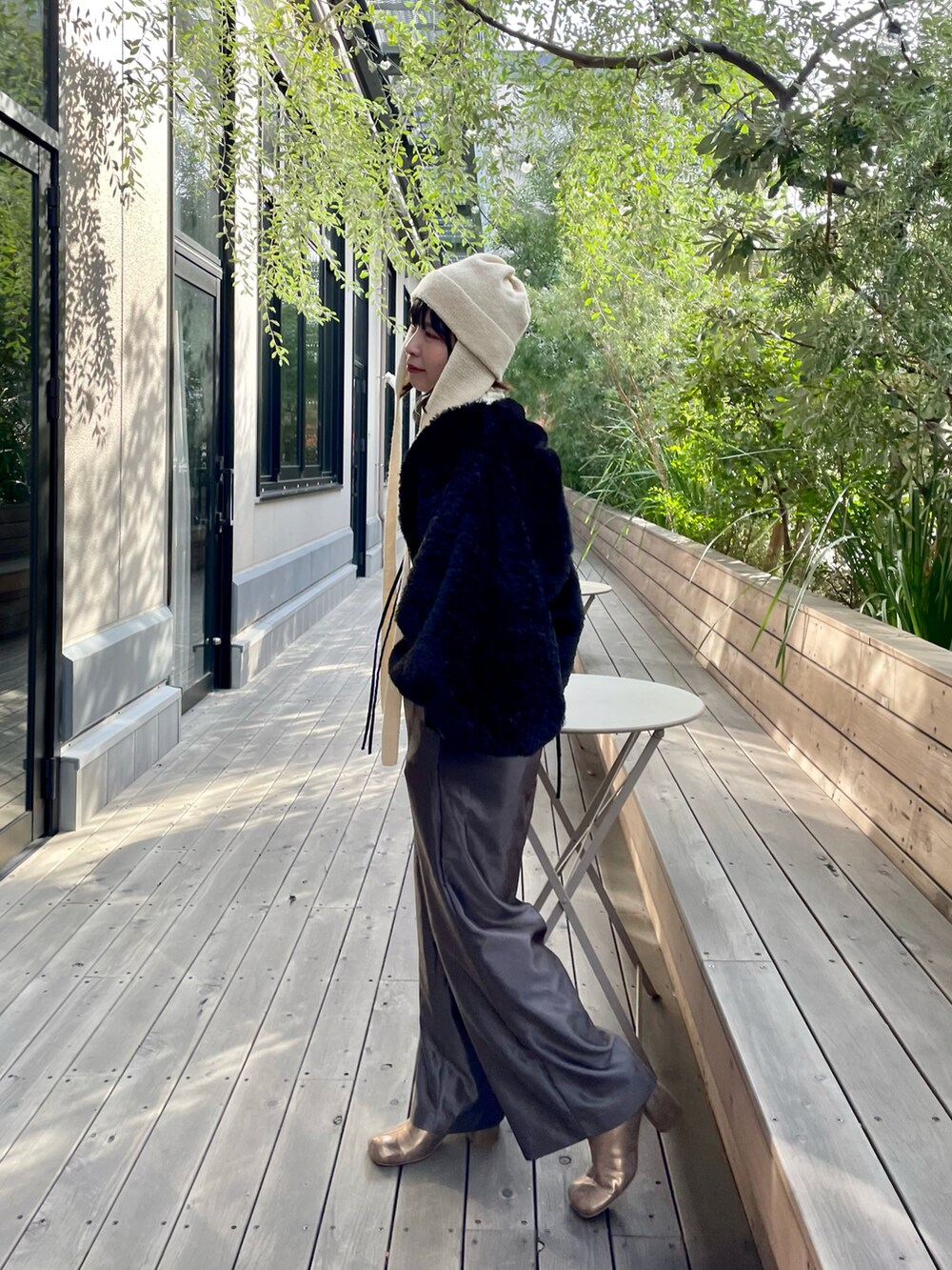 ブラック系のその他アウター、ホワイト系のニットキャップ/ビーニーを着用したレディースの冬コーディネートの2枚目の写真