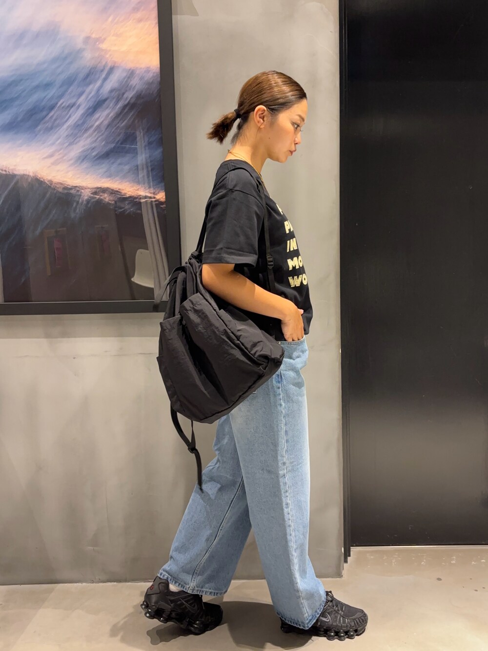 ブラック系のTシャツ/カットソー、ブルー系のデニムパンツ、ブラック系のバックパック/リュックを着用したレディースの夏コーディネートの3枚目の写真