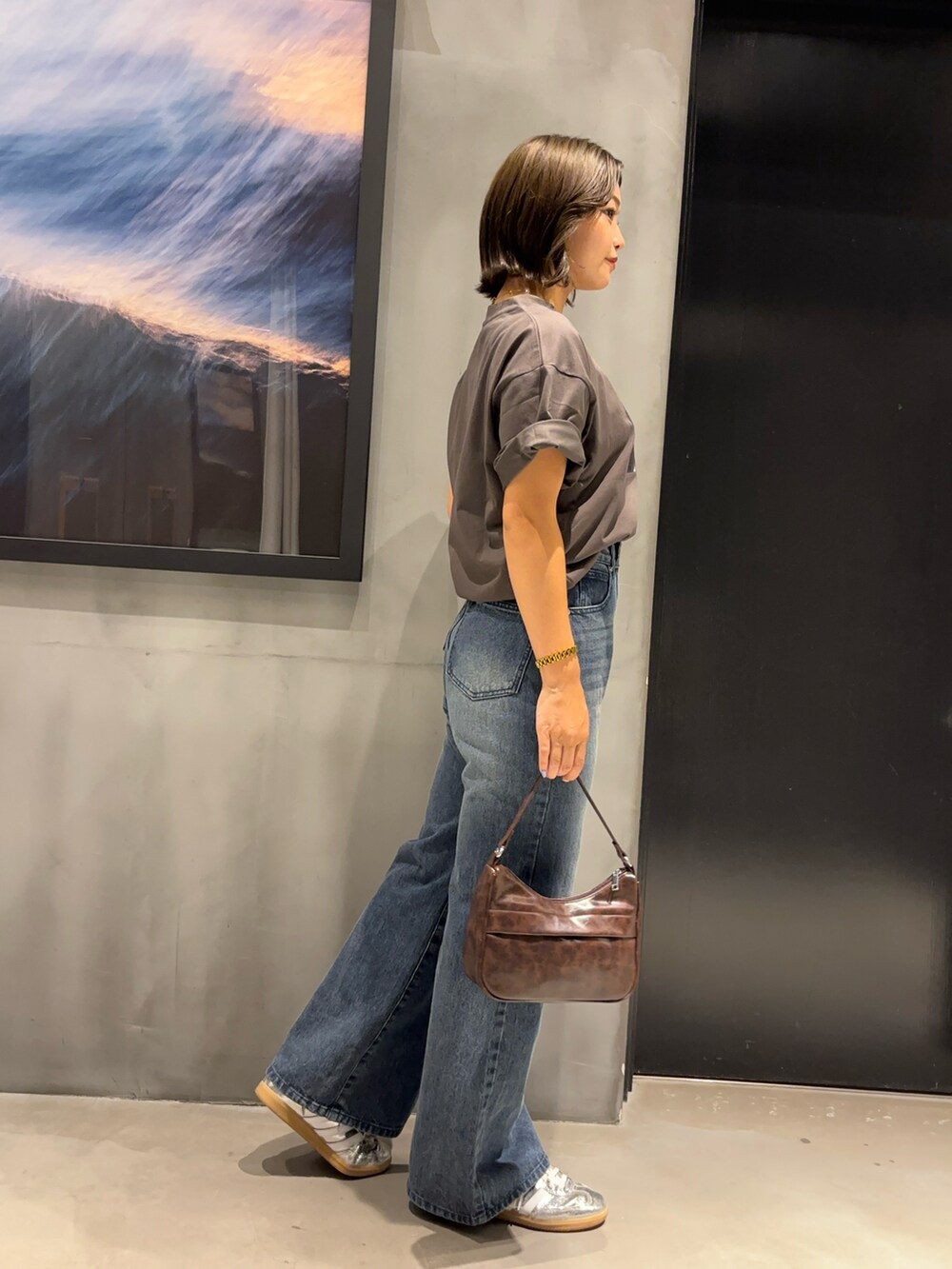 ホワイト系のTシャツ/カットソー、ブルー系のデニムパンツ、ブラウン系のハンドバッグを着用したレディースの夏コーディネートの3枚目の写真