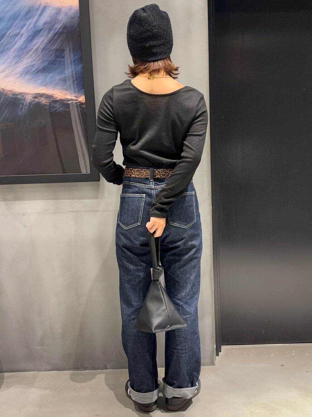 ブルー系のデニムパンツ、ブラック系のハンドバッグ、ブラック系のTシャツ/カットソーを着用したレディースの秋コーディネートの2枚目の写真