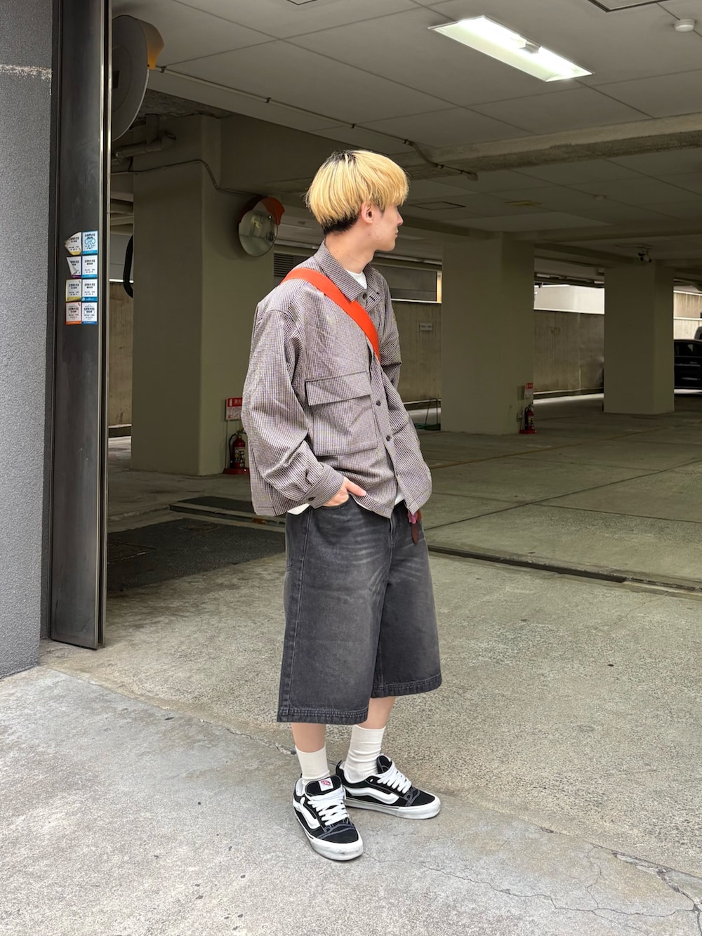 ブラック系のデニムパンツ、ベージュ系のブルゾンを着用したメンズの夏コーディネートの2枚目の写真