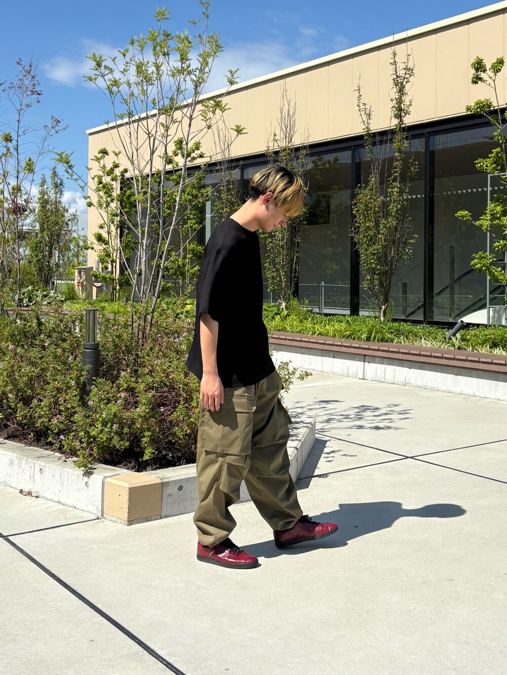 ブラック系のTシャツ/カットソー、グリーン系のカーゴパンツを着用したメンズの夏コーディネートの2枚目の写真