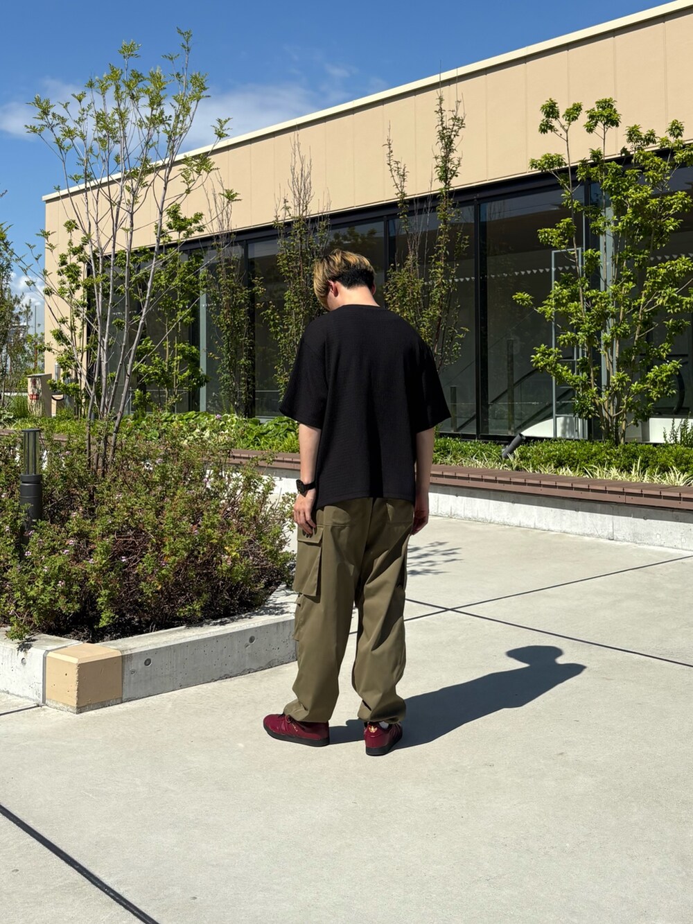 ブラック系のTシャツ/カットソー、グリーン系のカーゴパンツを着用したメンズの夏コーディネートの3枚目の写真