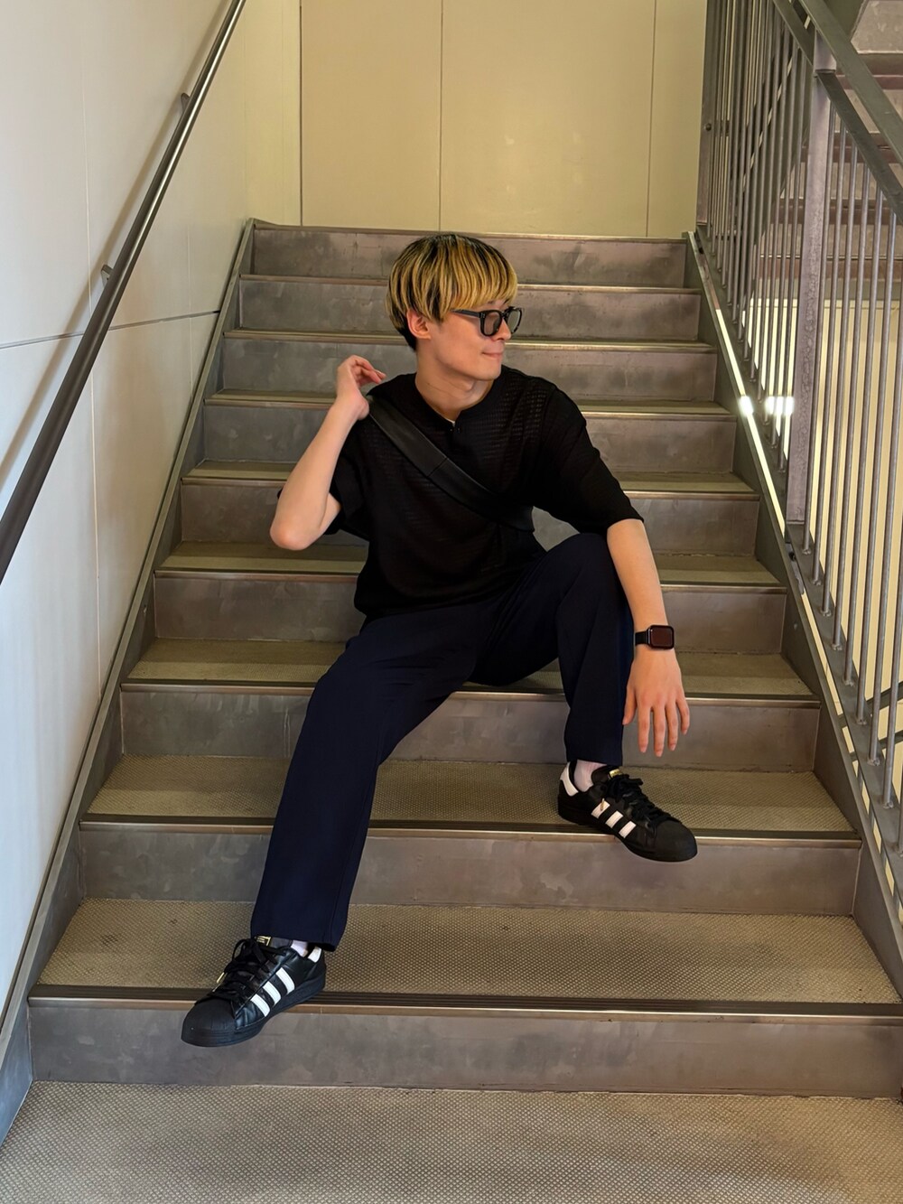 ブラック系のTシャツ/カットソー、ブラック系のショルダーバッグ、ブルー系のスラックスを着用したメンズの夏コーディネートの2枚目の写真