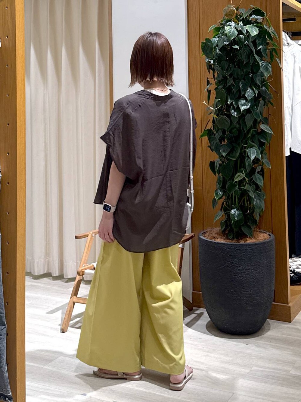 グレー系のシャツ/ブラウス、イエロー系のその他パンツ、ホワイト系のサンダルを着用したレディースの夏コーディネートの4枚目の写真