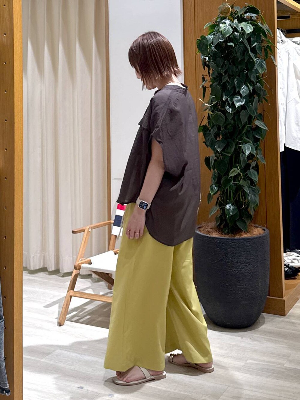 グレー系のシャツ/ブラウス、イエロー系のその他パンツ、ホワイト系のサンダルを着用したレディースの夏コーディネートの3枚目の写真