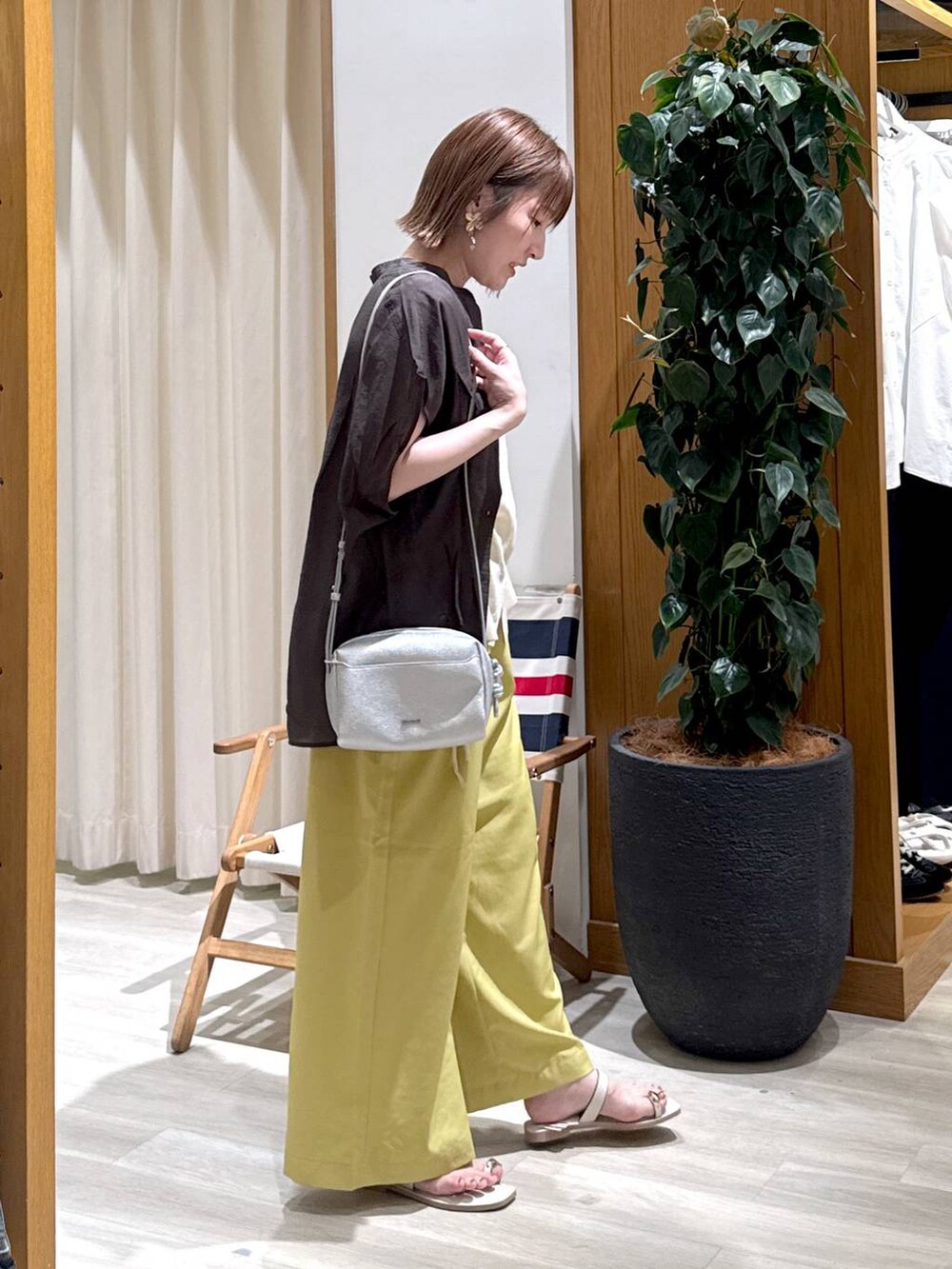 グレー系のシャツ/ブラウス、イエロー系のその他パンツ、ホワイト系のサンダルを着用したレディースの夏コーディネートの6枚目の写真