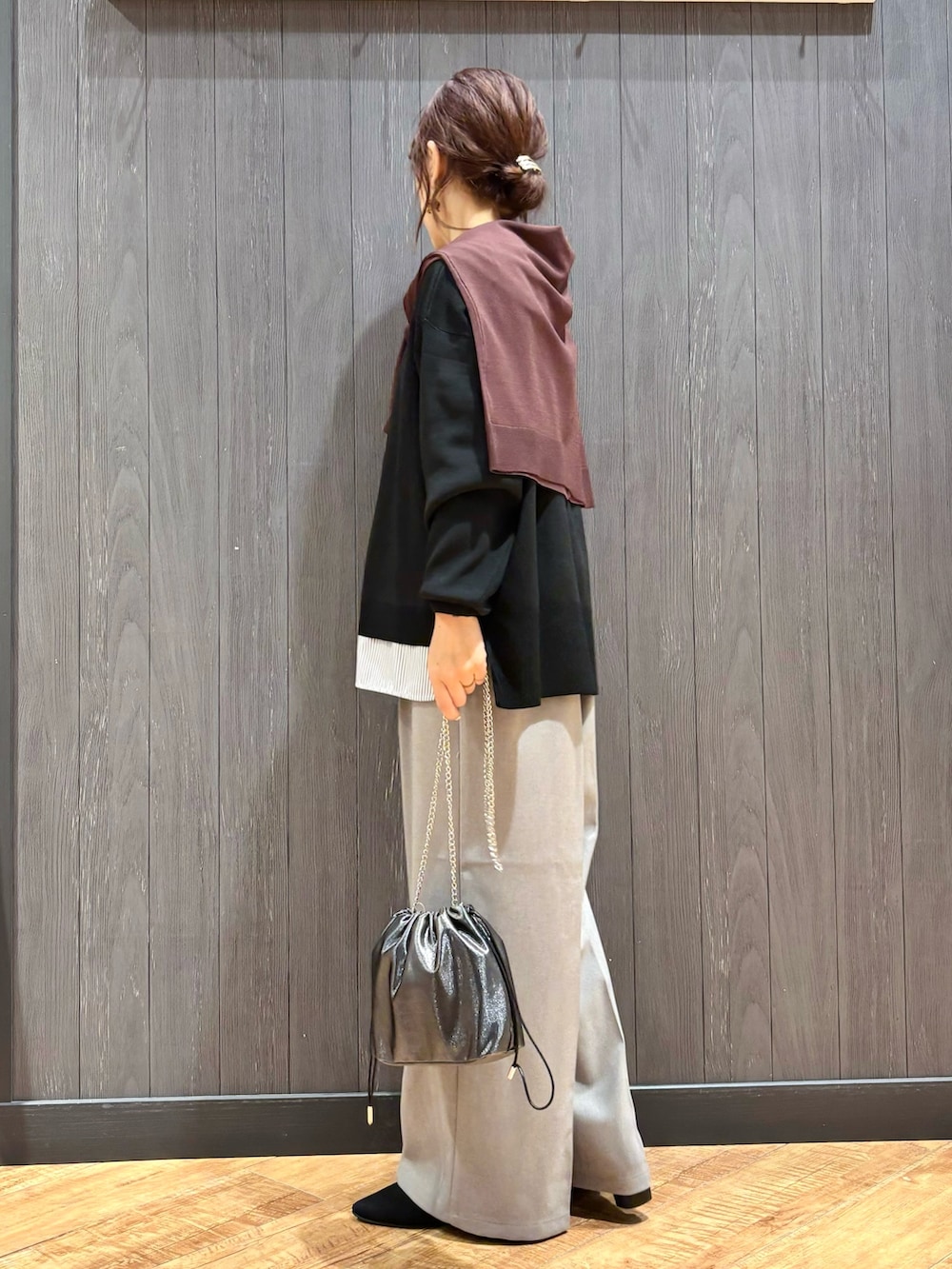 グレー系のショルダーバッグ、グレー系のその他パンツ、ブラック系のニット/セーターを着用したレディースの秋コーディネートの2枚目の写真