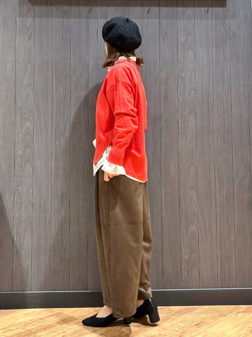 オレンジ系のニット/セーター、ホワイト系のシャツ/ブラウス、ブラウン系のその他パンツを着用したレディースの秋コーディネートの2枚目の写真