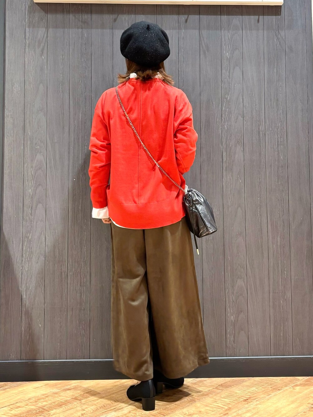 オレンジ系のニット/セーター、ホワイト系のシャツ/ブラウス、ブラウン系のその他パンツを着用したレディースの秋コーディネートの3枚目の写真