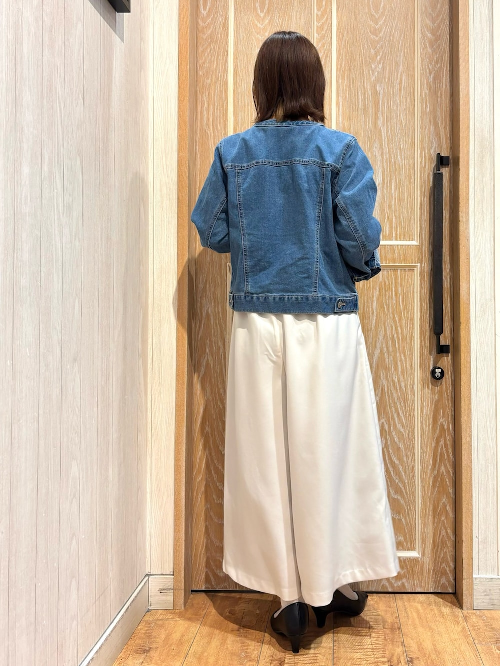 ブルー系のデニムジャケット、グレー系のニット/セーター、ホワイト系のその他パンツを着用したレディースの春コーディネートの3枚目の写真