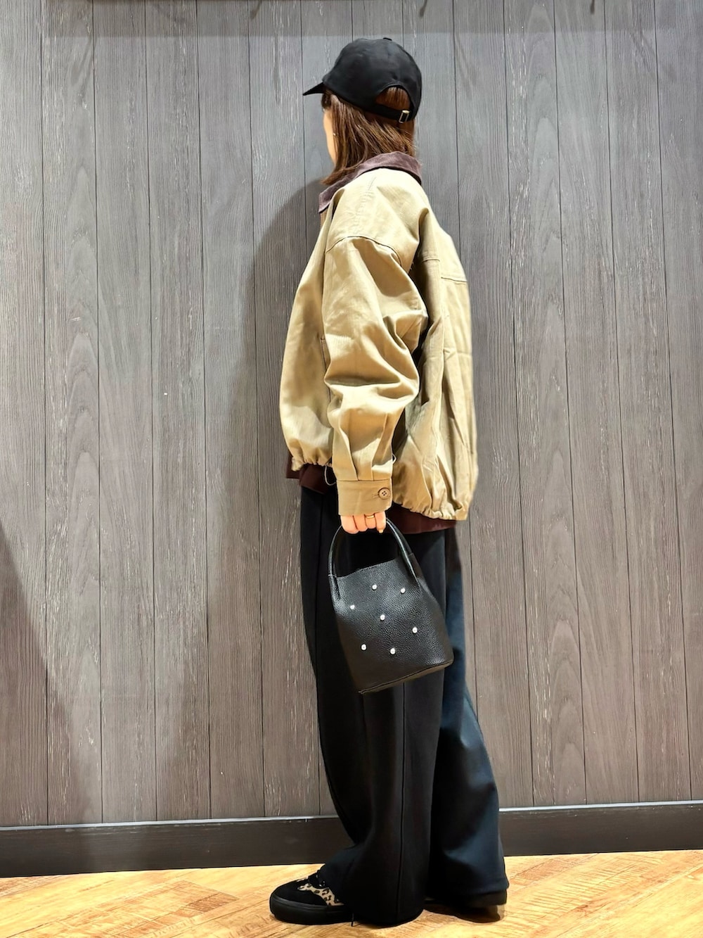 イエロー系のブルゾン、ブラウン系のスウェット、ホワイト系のTシャツ/カットソーを着用したレディースの秋コーディネートの2枚目の写真
