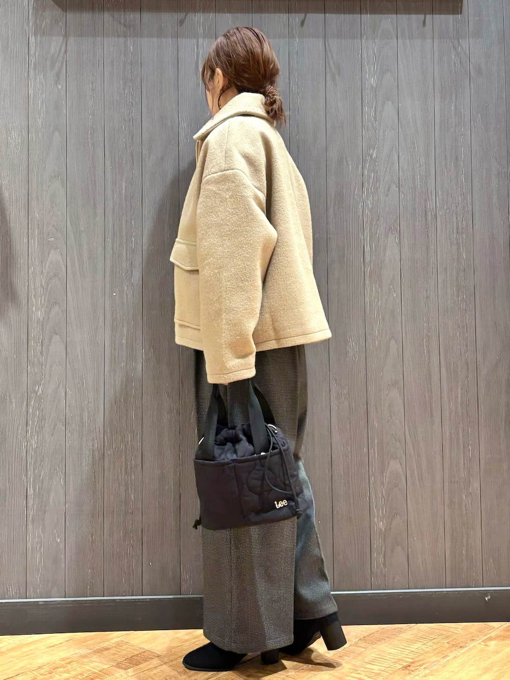 ベージュ系のブルゾン、ブラック系のショルダーバッグ、ブラック系のブーツを着用したレディースの秋コーディネートの2枚目の写真