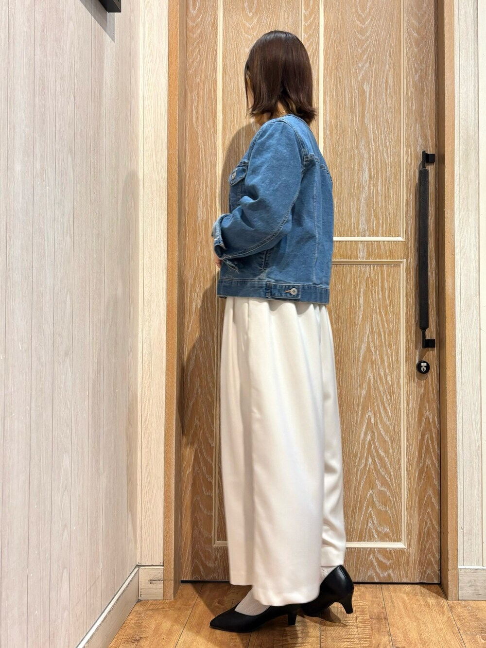 ブルー系のデニムジャケット、グレー系のニット/セーター、ホワイト系のその他パンツを着用したレディースの春コーディネートの2枚目の写真