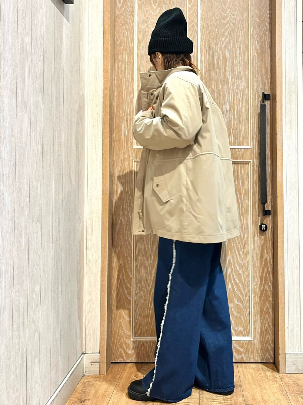 ベージュ系のその他アウター、ブラック系のニット/セーター、ブルー系のデニムパンツを着用したレディースの秋コーディネートの2枚目の写真