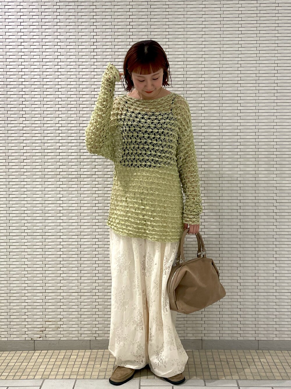 グリーン系のニット/セーター、ホワイト系のその他パンツ、ベージュ系のボストンバッグを着用したレディースの春コーディネートの2枚目の写真