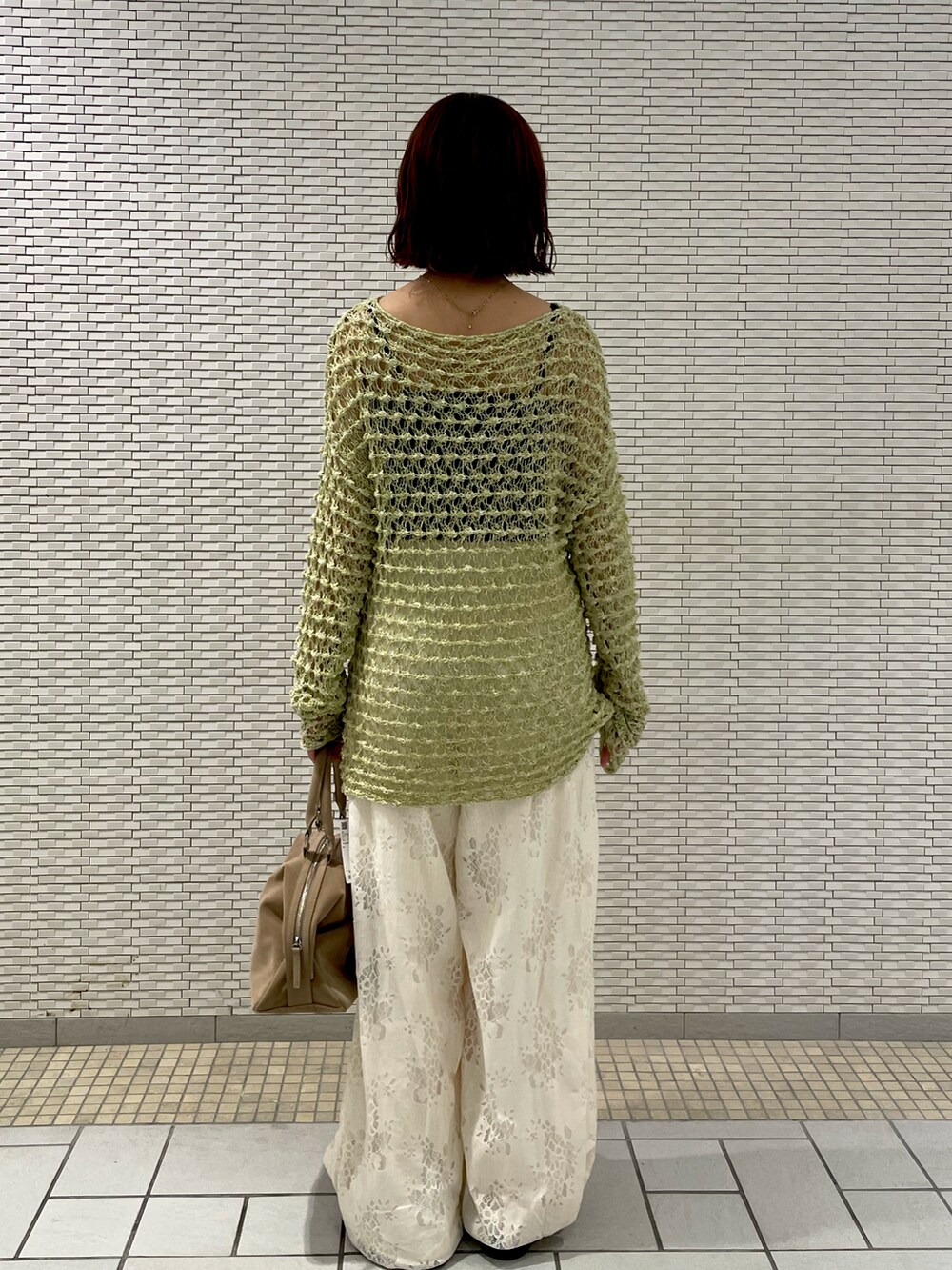 グリーン系のニット/セーター、ホワイト系のその他パンツ、ベージュ系のボストンバッグを着用したレディースの春コーディネートの4枚目の写真