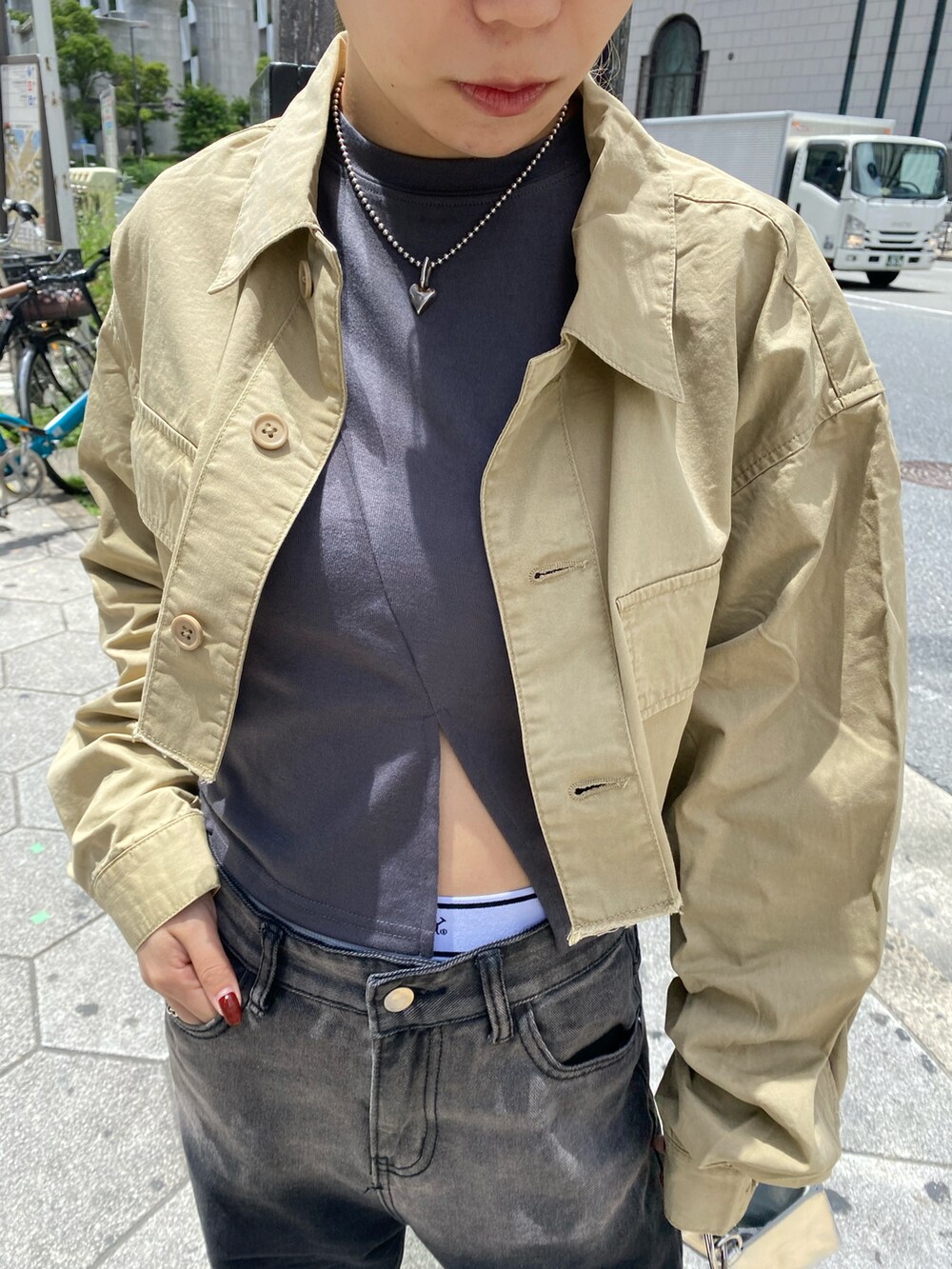ブラック系のデニムパンツ、グレー系のTシャツ/カットソー、シルバー系のショルダーバッグを着用したレディースの春コーディネートの2枚目の写真