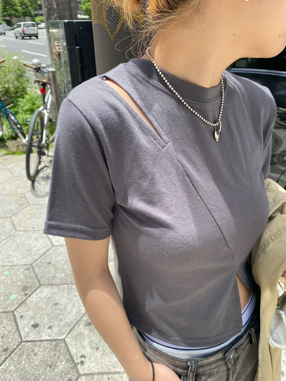 ブラック系のデニムパンツ、グレー系のTシャツ/カットソー、シルバー系のショルダーバッグを着用したレディースの春コーディネートの4枚目の写真