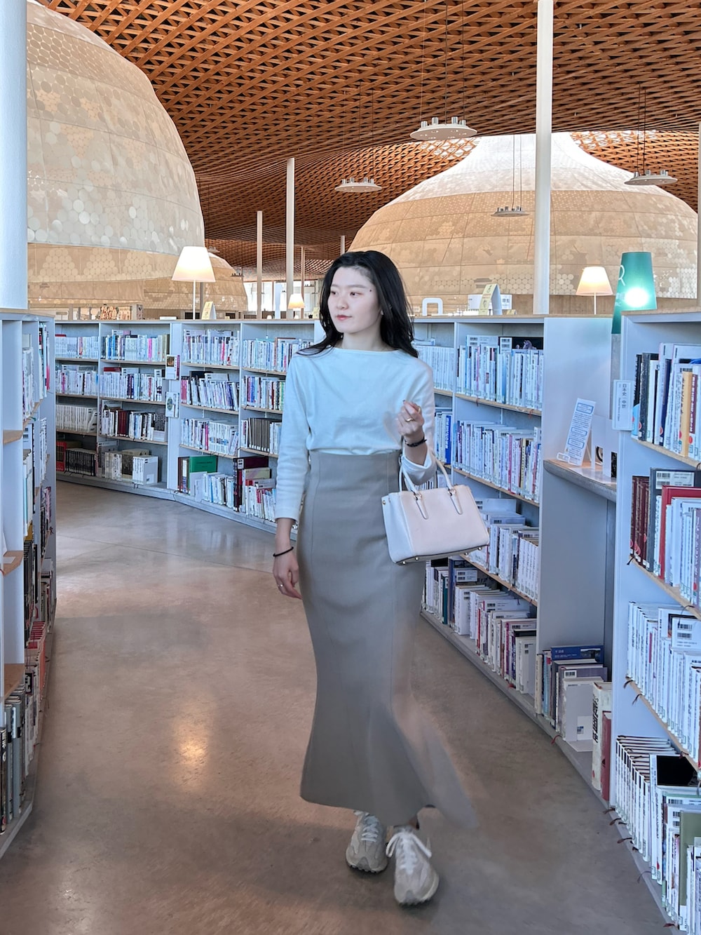 ベージュ系のスカート、ホワイト系のその他トップス、ホワイト系のスニーカーを着用したレディースの春コーディネートの2枚目の写真