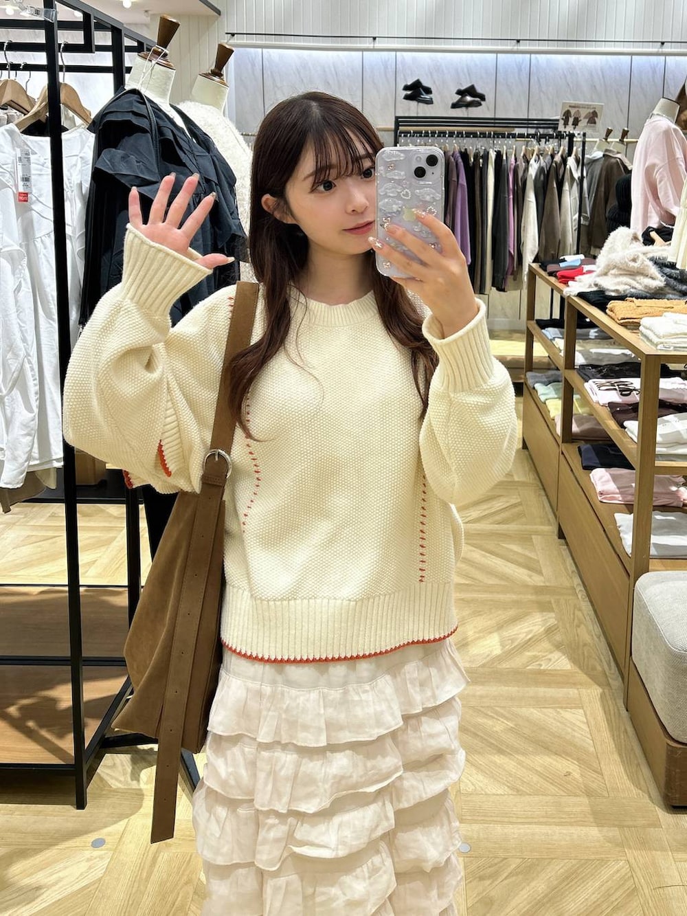 ホワイト系のニット/セーター、ホワイト系のスカート、ベージュ系のショルダーバッグを着用したレディースの秋コーディネートの2枚目の写真