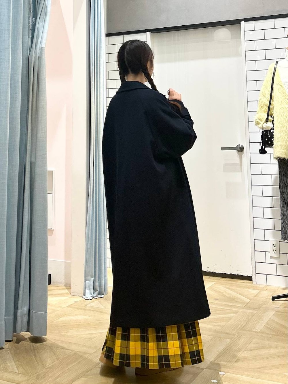 ブルー系のチェスターコート、イエロー系のスカート、ブラウン系のその他シューズを着用したレディースの秋コーディネートの3枚目の写真