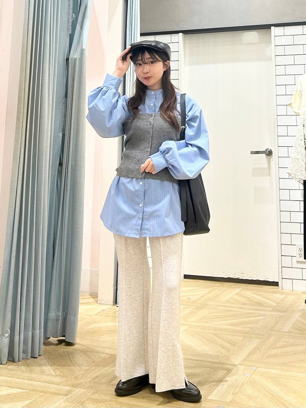 ブラック系のショルダーバッグ、ブルー系のシャツ/ブラウス、グレー系のニット/セーターを着用したレディースの秋コーディネートの4枚目の写真