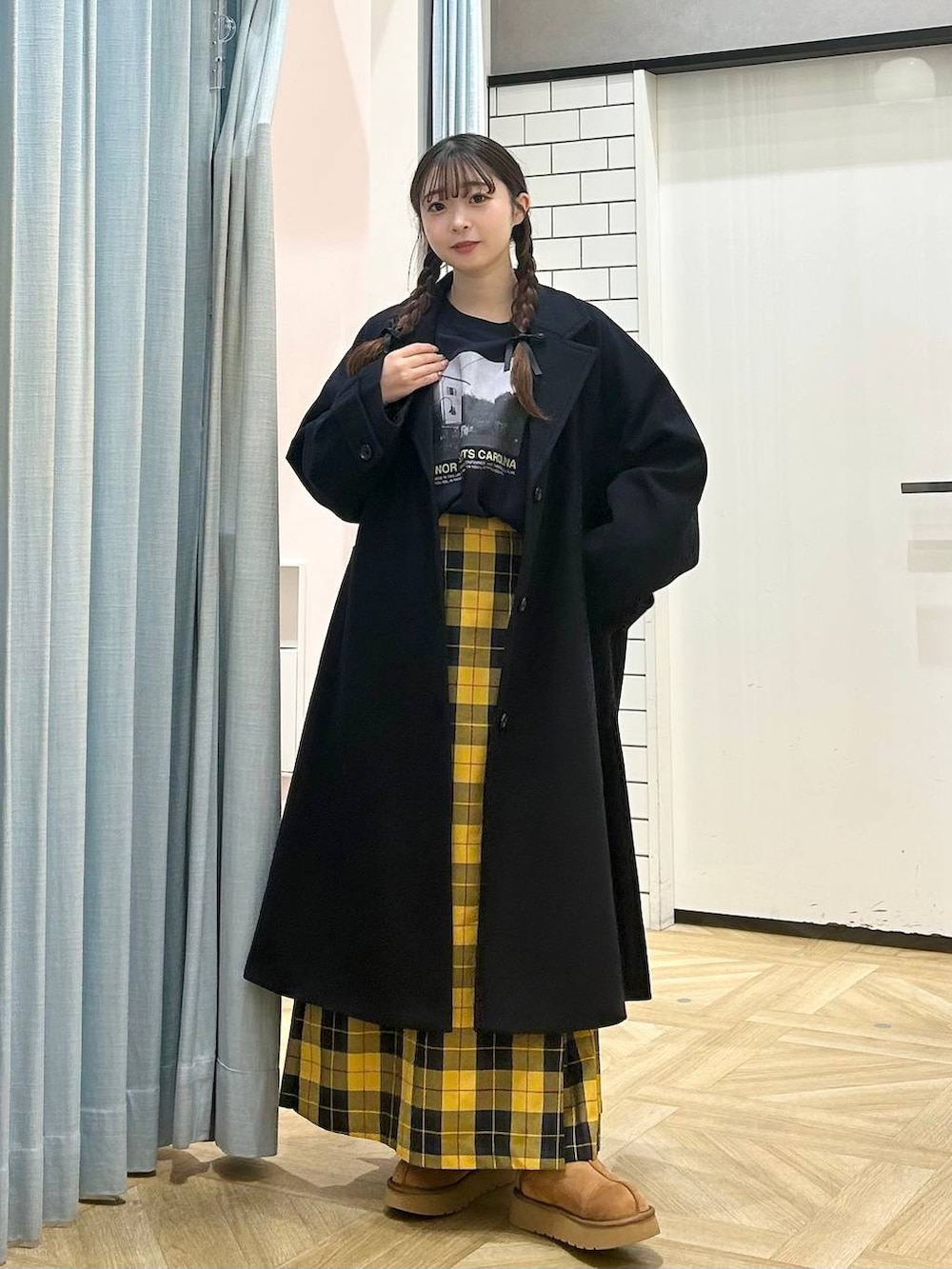ブルー系のチェスターコート、イエロー系のスカート、ブラウン系のその他シューズを着用したレディースの秋コーディネートの4枚目の写真