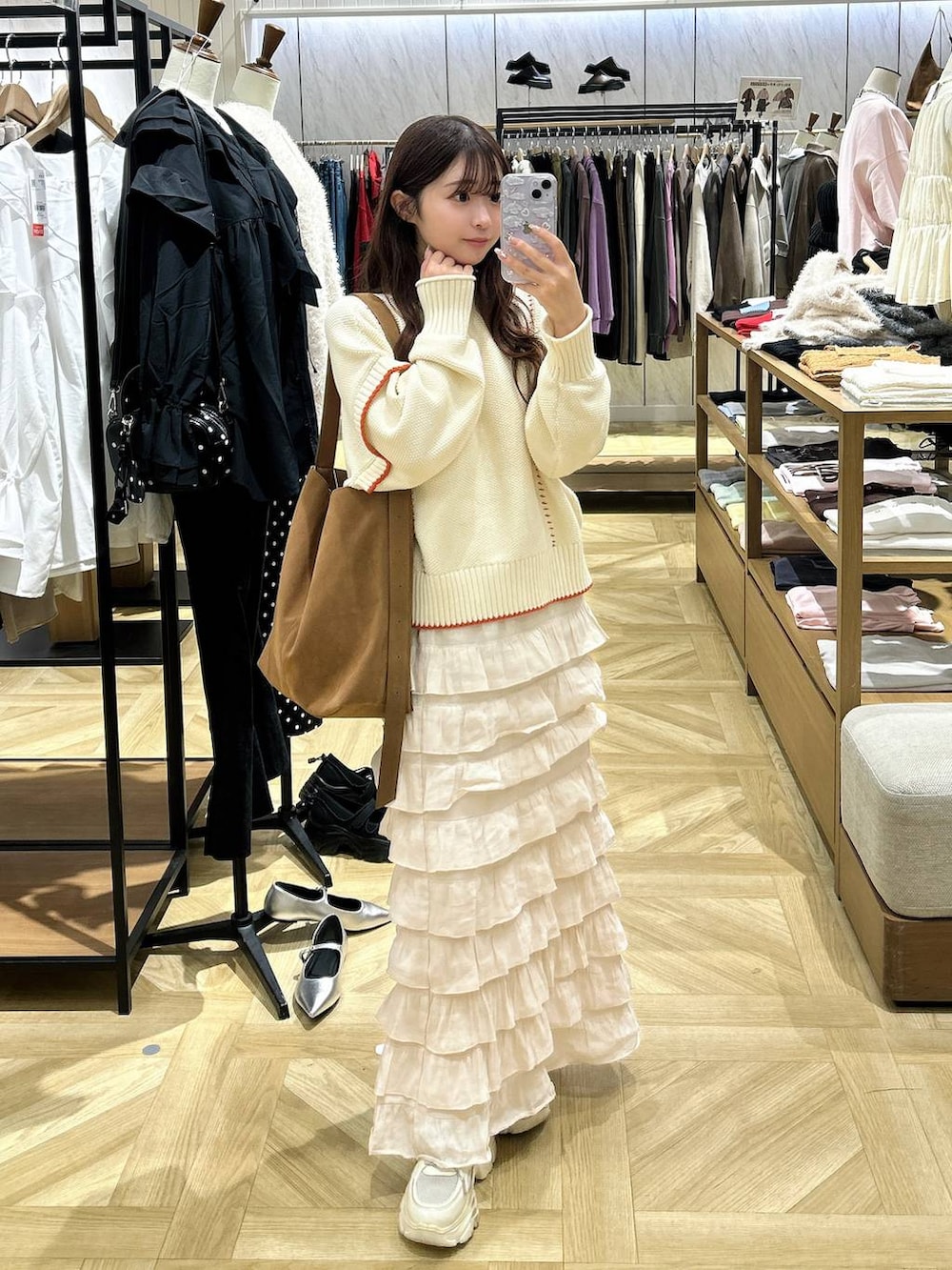 ホワイト系のニット/セーター、ホワイト系のスカート、ベージュ系のショルダーバッグを着用したレディースの秋コーディネートの3枚目の写真