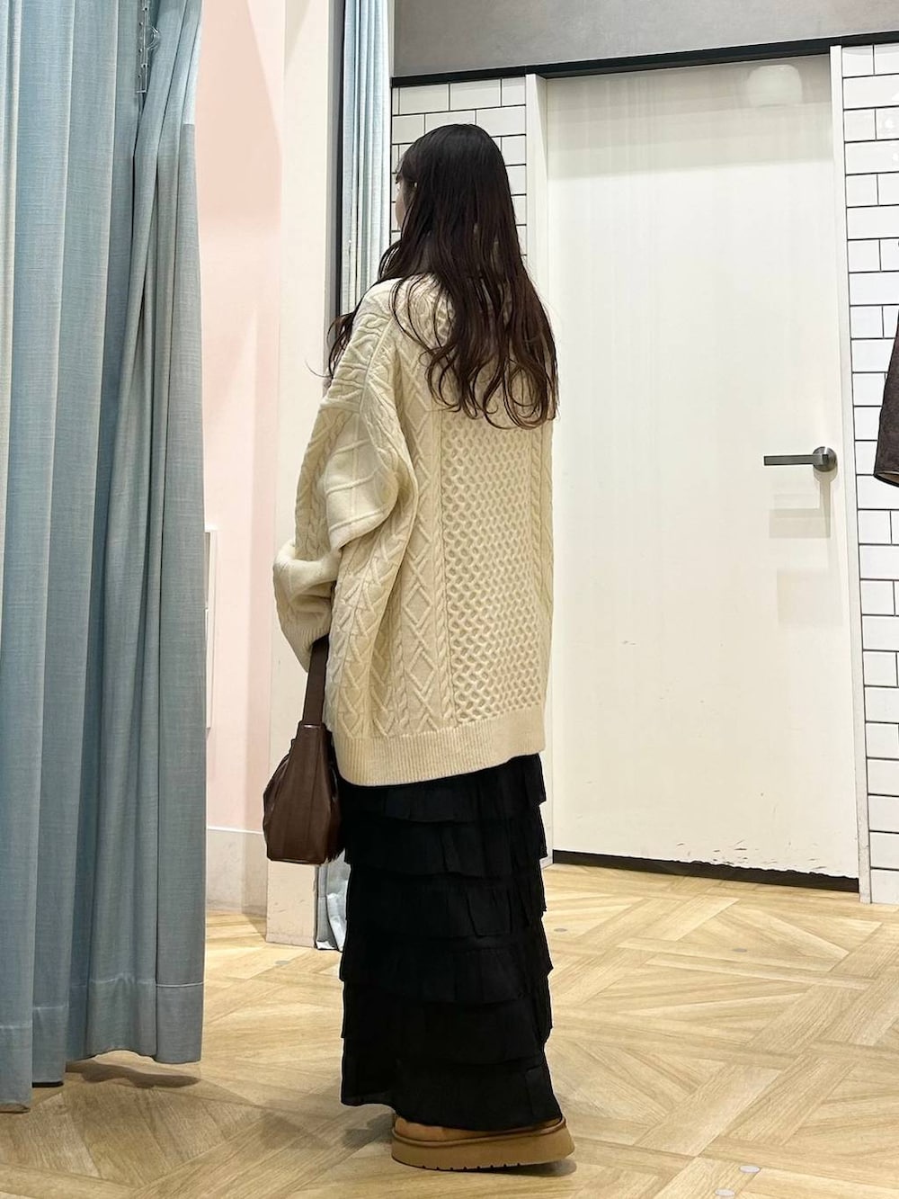 ブラック系のスカート、ブラウン系のその他シューズ、ブラウン系のショルダーバッグを着用したレディースの冬コーディネートの2枚目の写真