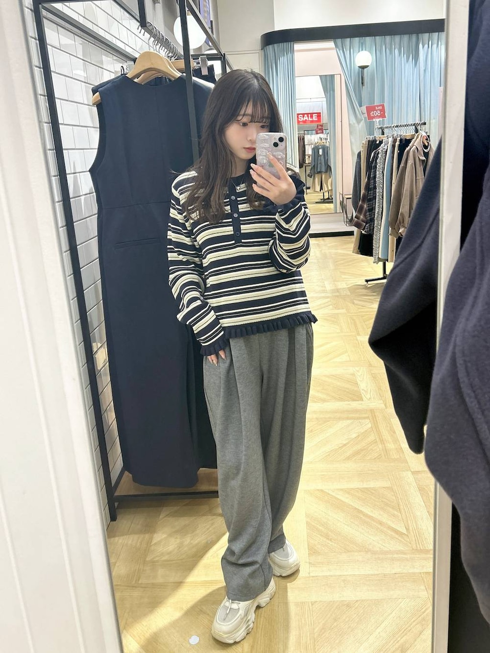 グレー系のスウェットパンツ、ブルー系のニット/セーター、ホワイト系のスニーカーを着用したレディースの冬コーディネートの2枚目の写真