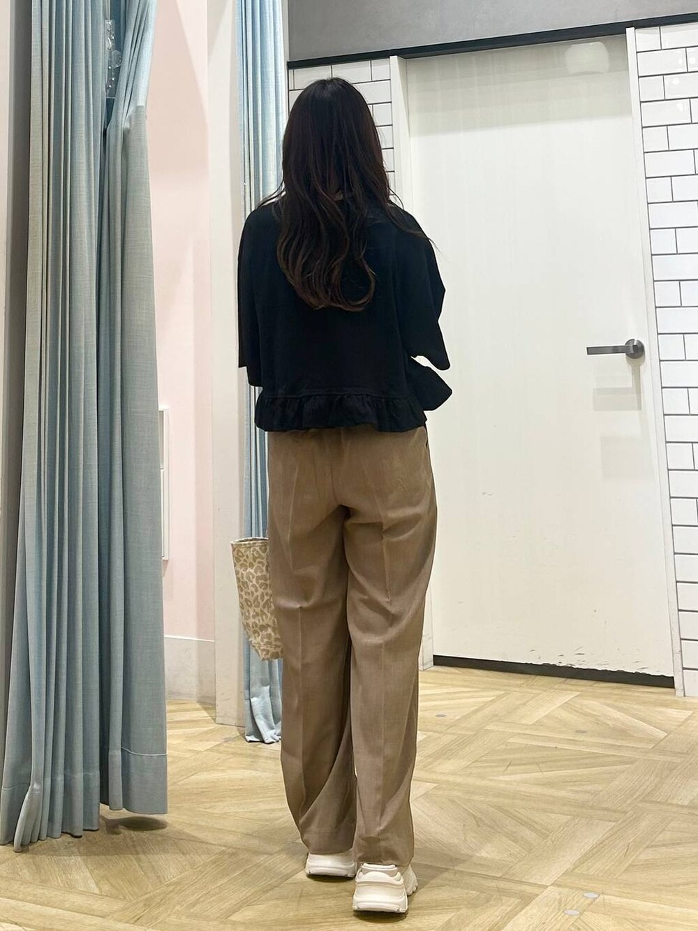 ホワイト系のサンダル、ベージュ系のショルダーバッグ、ベージュ系のスラックスを着用したレディースの夏コーディネートの3枚目の写真