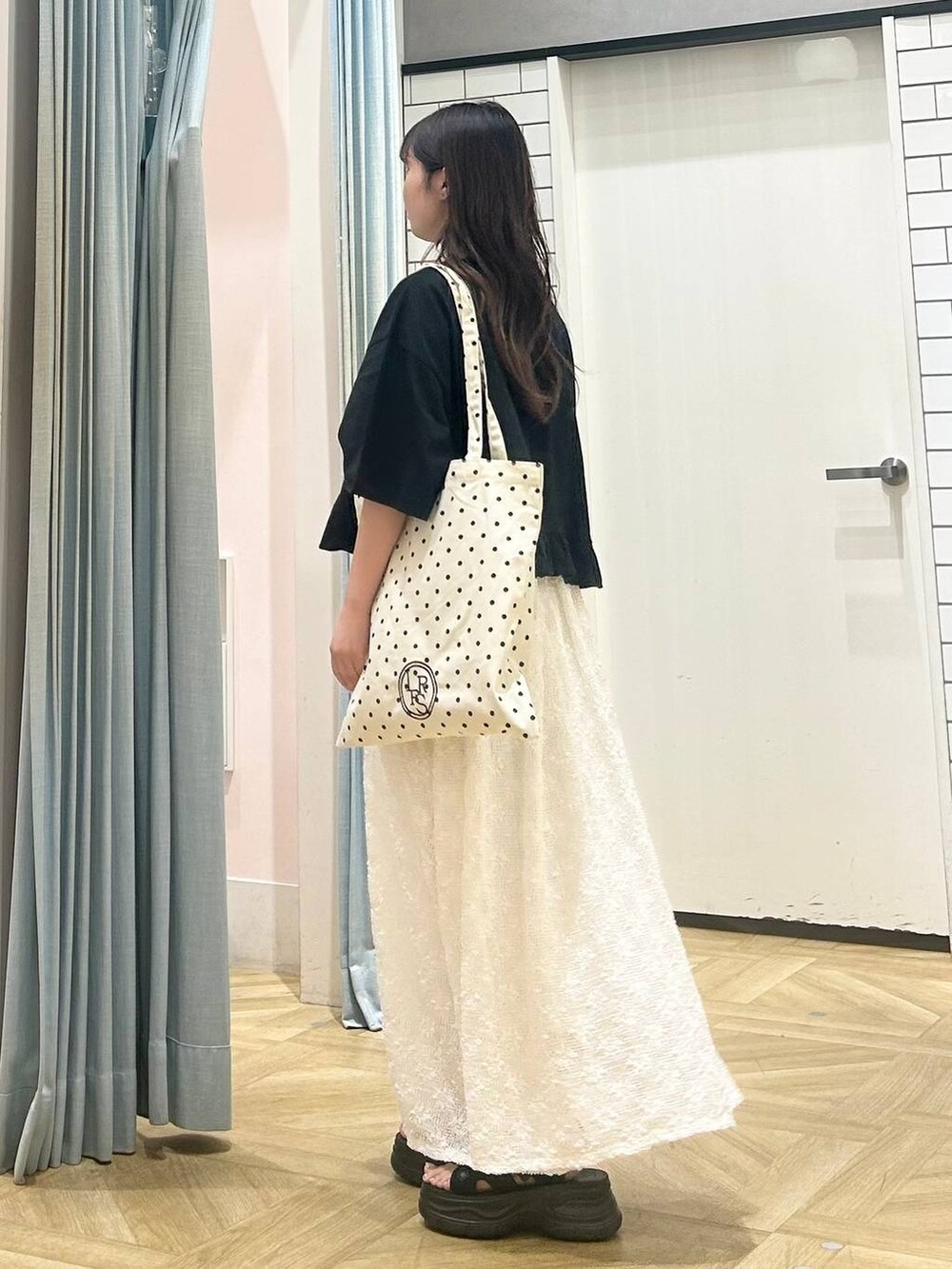 ブラック系のサンダル、その他のトートバッグ、ブラック系のTシャツ/カットソーを着用したレディースの夏コーディネートの2枚目の写真