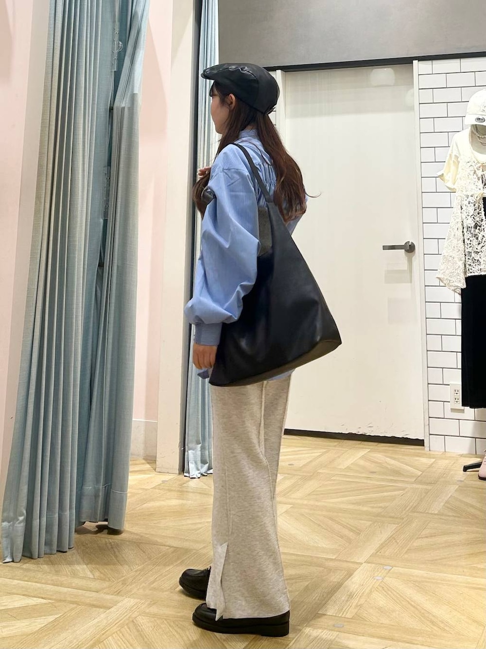 ブラック系のショルダーバッグ、ブルー系のシャツ/ブラウス、グレー系のニット/セーターを着用したレディースの秋コーディネートの2枚目の写真