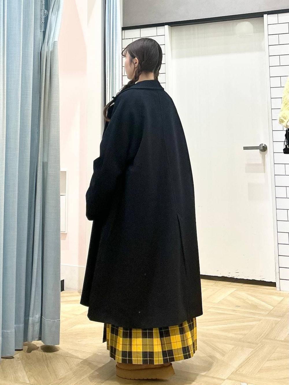 ブルー系のチェスターコート、イエロー系のスカート、ブラウン系のその他シューズを着用したレディースの秋コーディネートの2枚目の写真