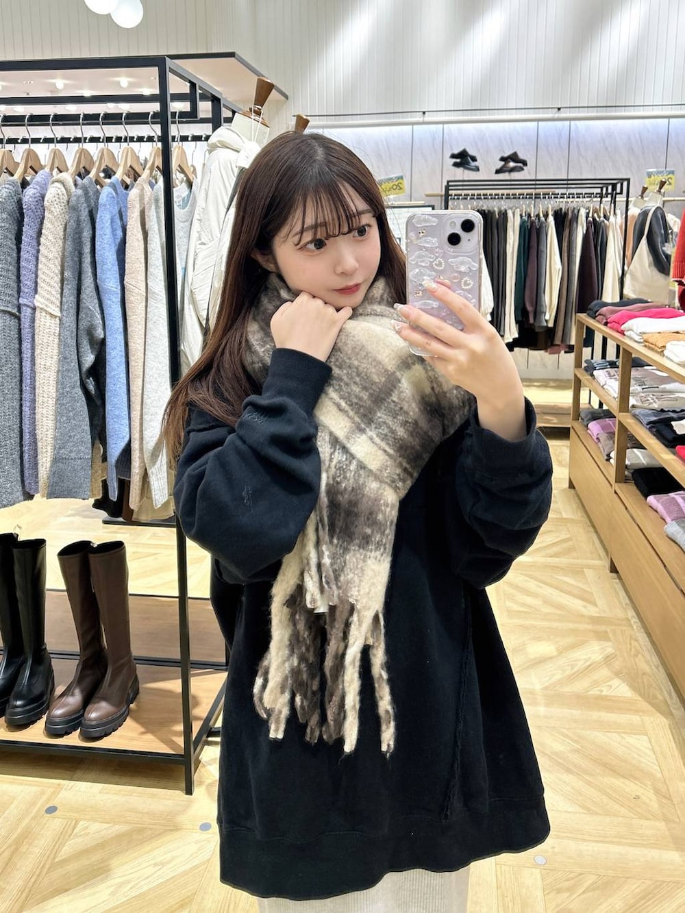 グレー系のスカート、ベージュ系のショルダーバッグ、ブラック系のスウェットを着用したレディースの秋コーディネートの3枚目の写真