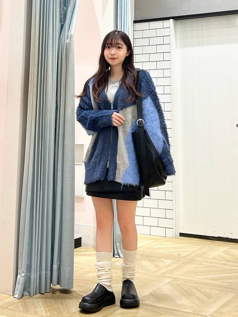 ブラック系のサンダル、ブラック系のショルダーバッグ、ブラック系のスカートを着用したレディースの秋コーディネートの4枚目の写真