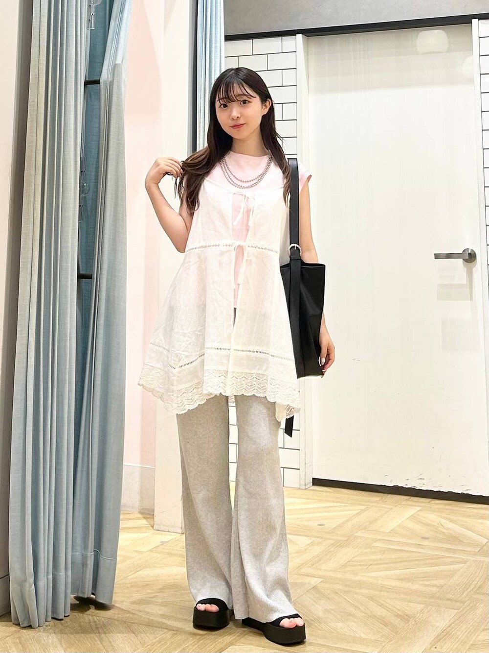 ブラック系のサンダル、ホワイト系のワンピース、ブラック系のショルダーバッグを着用したレディースの夏コーディネートの4枚目の写真