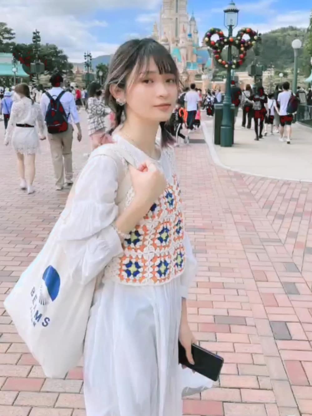 ブラウン系のその他シューズ、ホワイト系のトートバッグ、オレンジ系のカーディガン/ボレロを着用したレディースの秋コーディネートの4枚目の写真