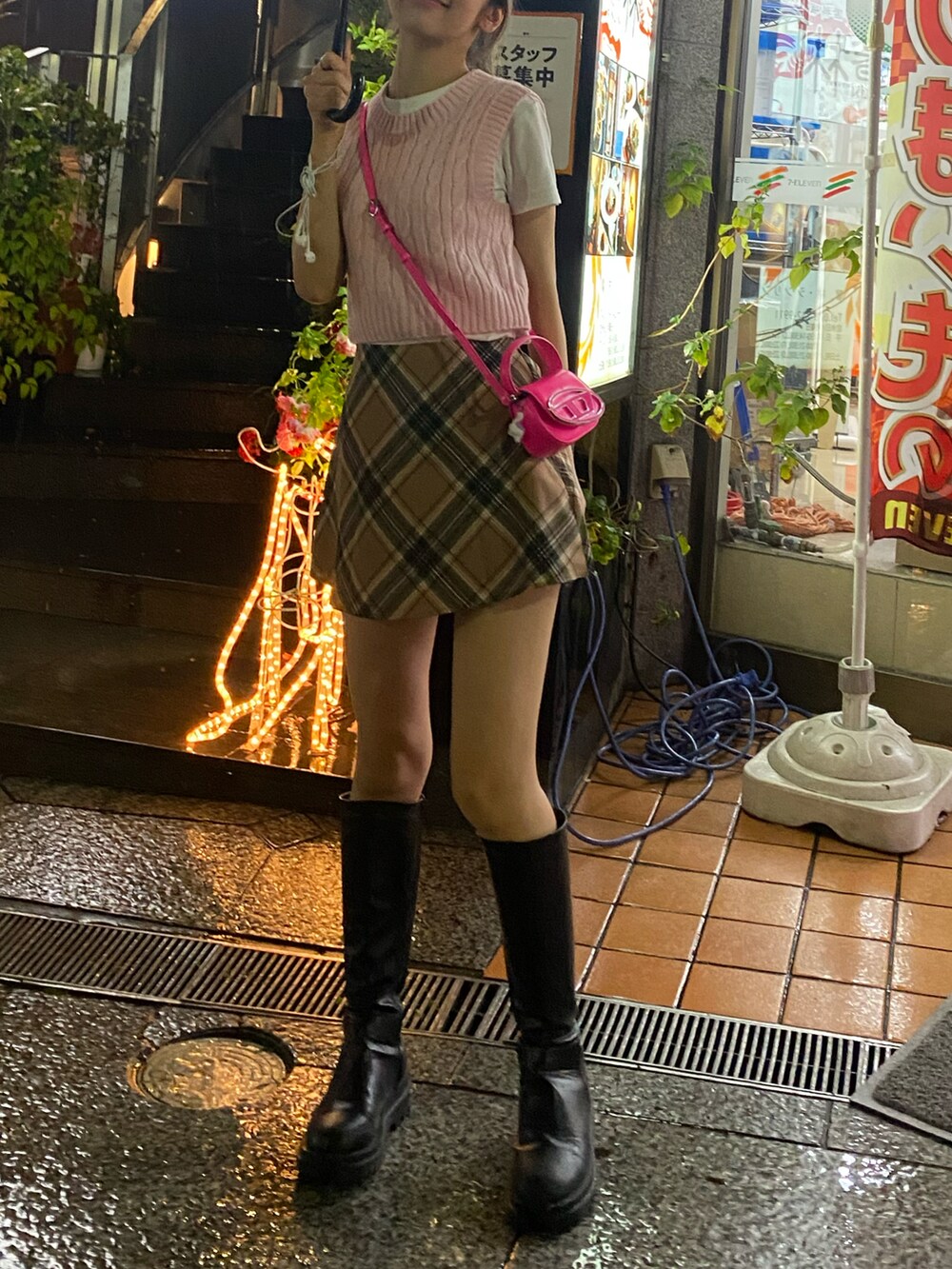 ピンク系のベスト、ベージュ系のスカート、ピンク系のショルダーバッグを着用したレディースの春コーディネートの2枚目の写真