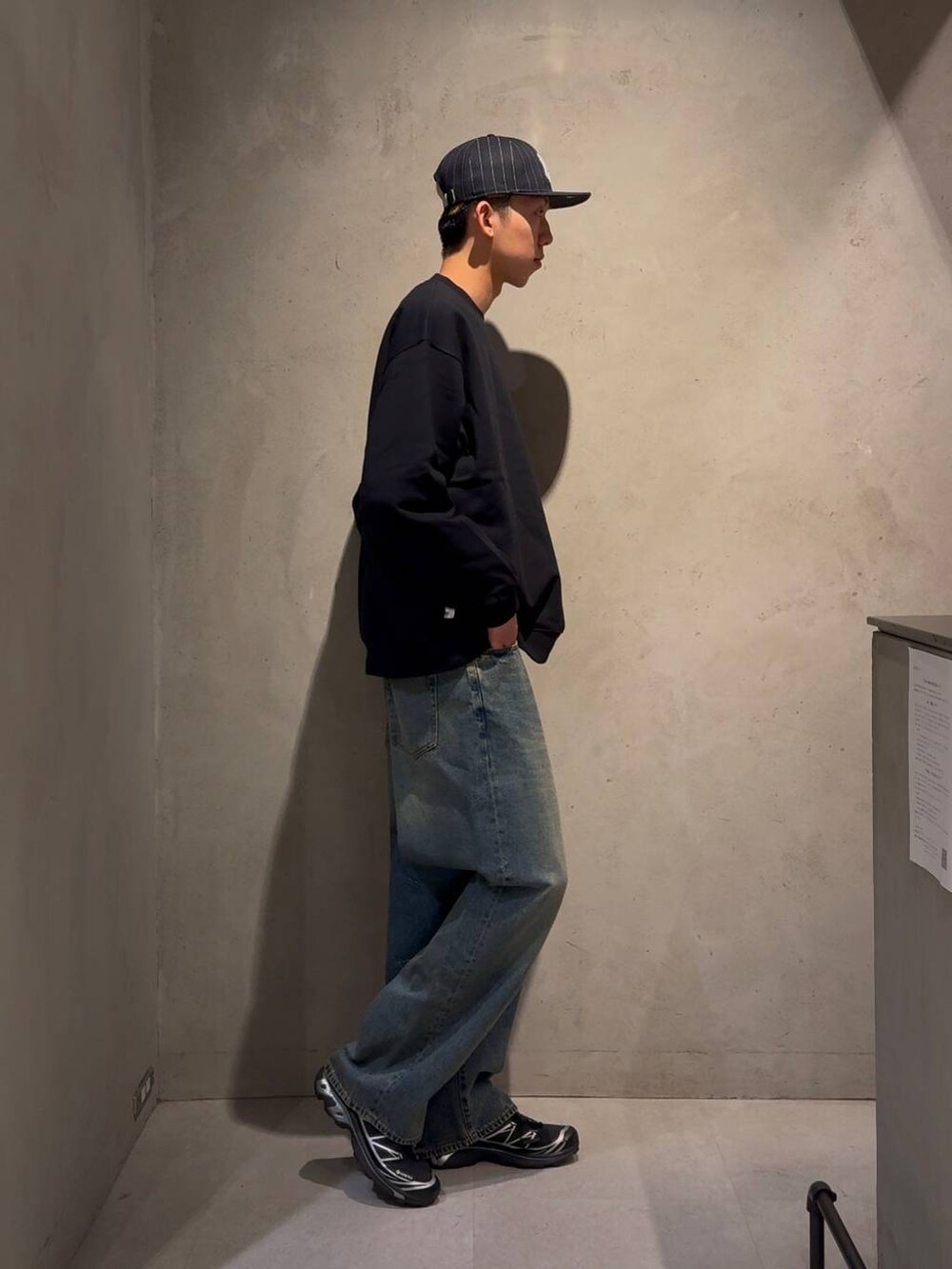 ブルー系のデニムパンツ、ブルー系のスウェット、ブルー系のキャップを着用したメンズの冬コーディネートの2枚目の写真