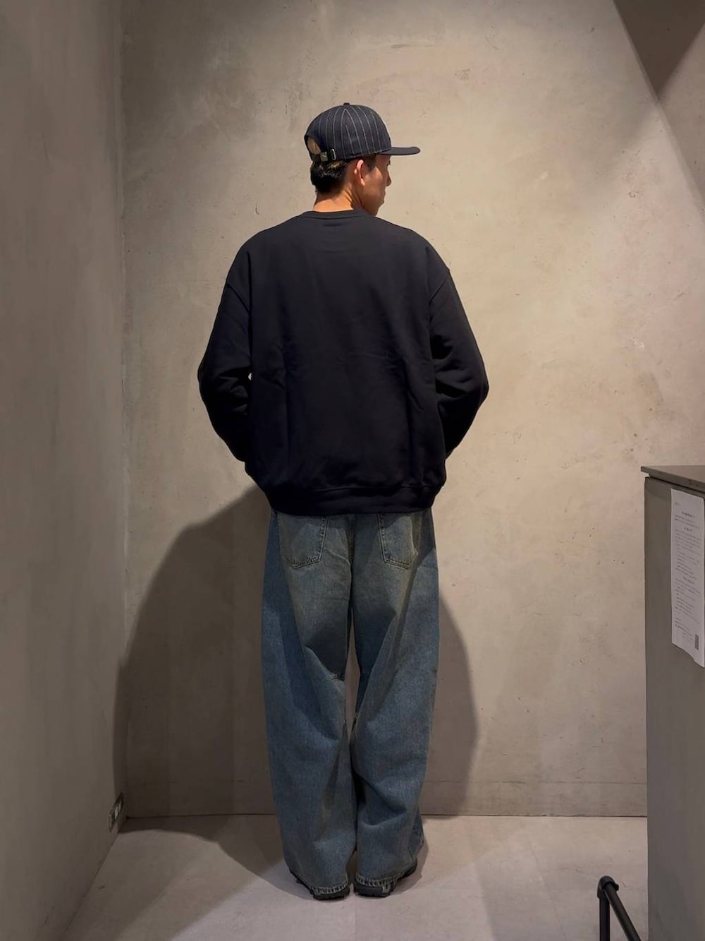 ブルー系のデニムパンツ、ブルー系のスウェット、ブルー系のキャップを着用したメンズの冬コーディネートの4枚目の写真