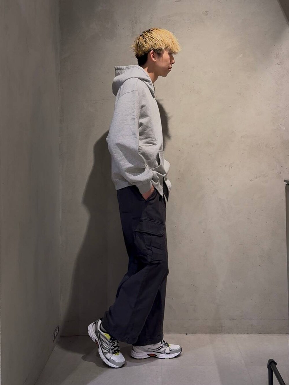 ブラック系のカーゴパンツ、グレー系のパーカー、ホワイト系のネックレスを着用したメンズの冬コーディネートの2枚目の写真
